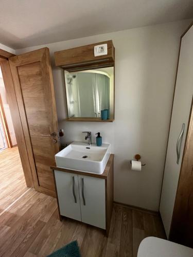 a bathroom with a white sink and a mirror at Lily B in Pakoštane
