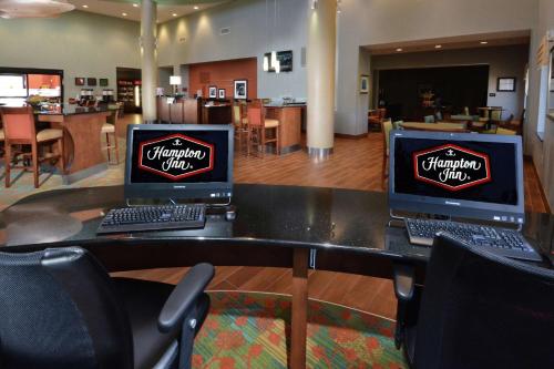 two computer monitors sitting on a table in a room at Hampton Inn Raleigh/Durham Airport in Morrisville