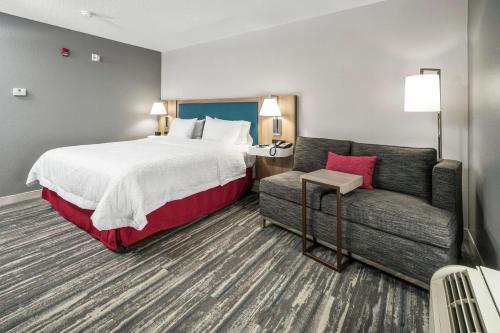 ein Hotelzimmer mit einem Bett und einem Sofa in der Unterkunft Hampton Inn Wilson Downtown in Wilson