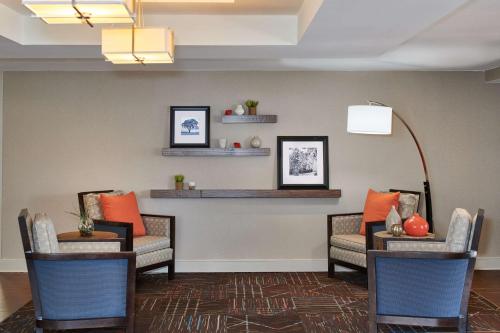 a waiting room with couches and chairs and shelves at Hampton Inn & Suites Chapel Hill/Durham in Chapel Hill