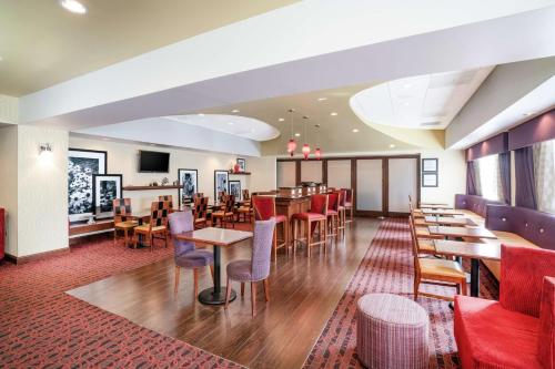 a restaurant with tables and chairs and a bar at Hampton Inn Richmond - Airport in Sandston