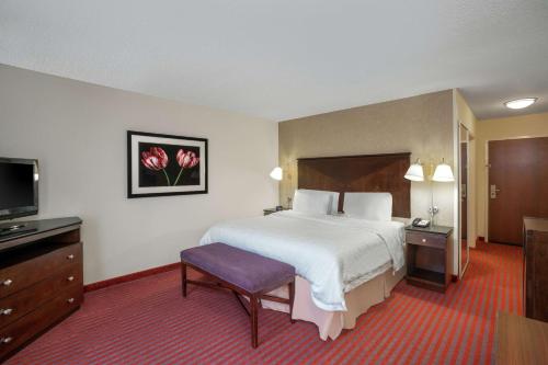 a hotel room with a bed and a flat screen tv at Hampton Inn Richmond - Airport in Sandston