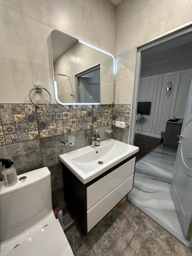 uma casa de banho com um lavatório, um WC e um espelho. em Verin antarain em Yerevan