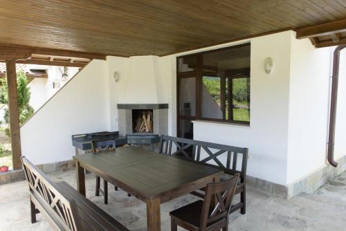 a table and chairs on a patio with a fireplace at KTB Manastira Holiday Village in Oreshak