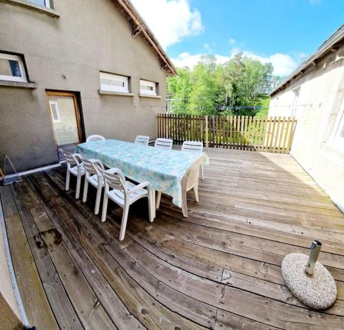 a table and chairs sitting on a wooden deck at Gîte La Scierie, Maison Familiale, Laguiole in Laguiole