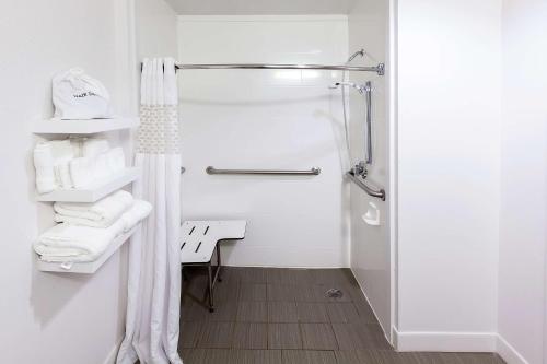 a white bathroom with a shower and a sink at Hampton Inn Raleigh/Garner in Garner