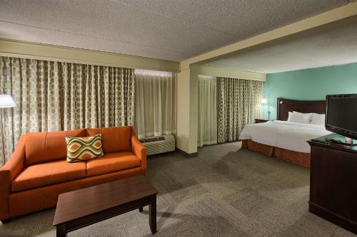 a hotel room with a bed and a couch at Hampton Inn Raleigh/Garner in Garner