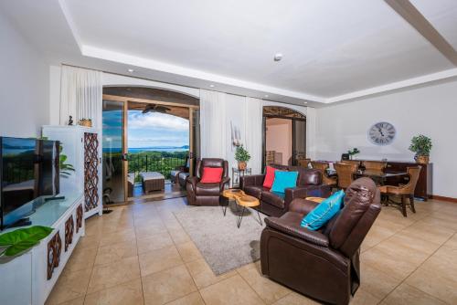sala de estar con muebles de cuero y TV de pantalla plana en Jobo 8 Luxury Apartment - Reserva Conchal, en Playa Conchal