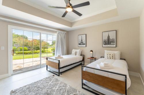 een slaapkamer met 2 bedden en een plafondventilator bij Modern Luxury Retreat in Kissimmee
