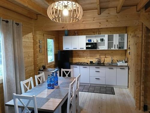 a kitchen with a table and chairs in a cabin at Świerkowe Siedlisko in Węgorzewo