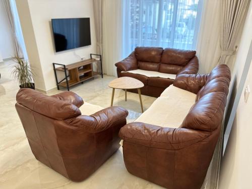 a living room with two leather chairs and a couch at Marini Casa in Ulcinj
