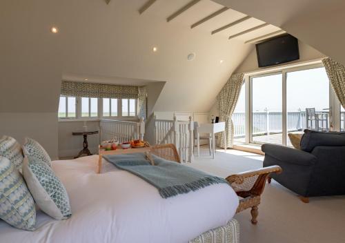 ein Schlafzimmer mit einem großen weißen Bett und ein Wohnzimmer in der Unterkunft The Pavilion in Orford