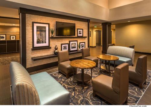 a hotel lobby with tables and chairs and a tv at Hampton Inn & Suites Reno in Reno