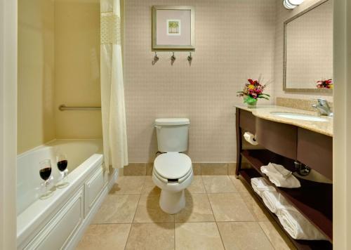 a bathroom with a toilet and a tub and a sink at Hampton Inn & Suites Reno in Reno