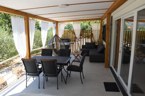 eine abgeschirmte Veranda mit einem Tisch und Stühlen in der Unterkunft Mobile home Pelješac, Camp Vala in Orebić