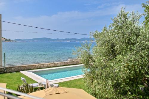 a swimming pool with the ocean in the background at Villa Hresc M in Zadar