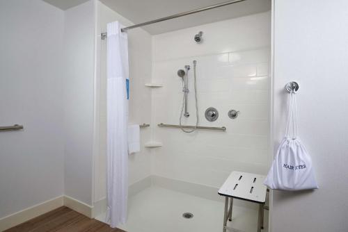 a white bathroom with a shower and a toilet at Hampton Inn & Suites Rogers in Rogers