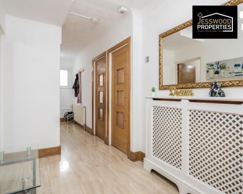 a bathroom with a mirror and a sink at Large 6 Bedroom Contractor House by Jesswood Properties Short Lets For Groups, Business And Leisure With Free Parking, Wifi and Pool Table in Luton