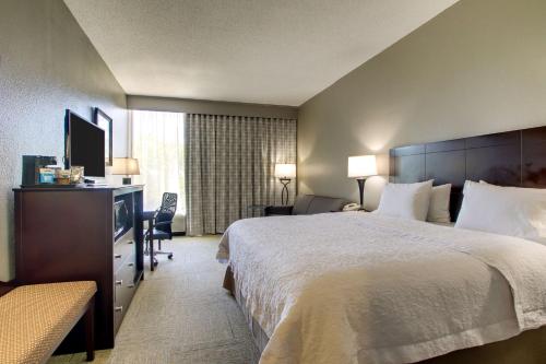 ein Hotelzimmer mit einem großen Bett und einem TV in der Unterkunft Hampton Inn Rolla in Rolla