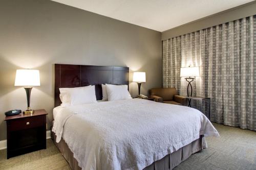 a hotel room with a large bed and two lamps at Hampton Inn Rolla in Rolla