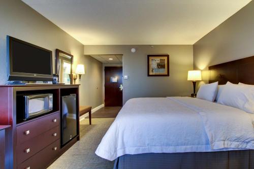 a hotel room with a bed and a flat screen tv at Hampton Inn Rolla in Rolla