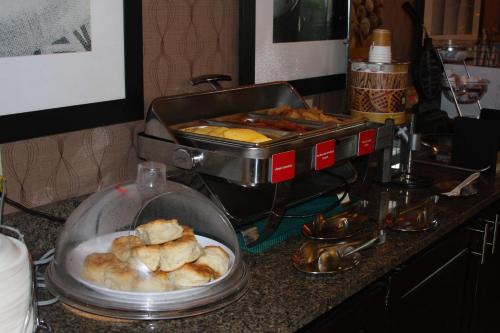 a counter top with a buffet of pastries and a bread machine at Hampton Inn Russellville in Russellville