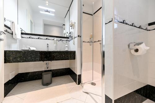 a bathroom with a glass shower and a sink at Villa Hresc M in Zadar