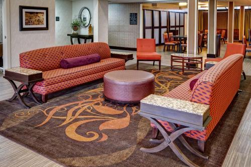 a lobby with two couches and tables and chairs at Hampton Inn Russellville in Russellville