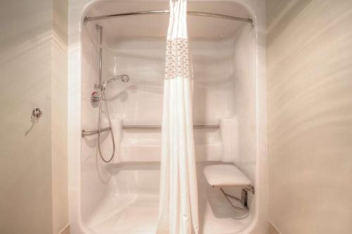 a bathroom with a shower with a white shower curtain at Hampton Inn Russellville in Russellville