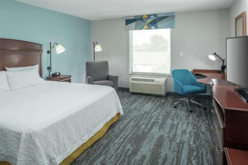a hotel room with a bed and a desk and chair at Hampton Inn & Suites Rochester-North in Rochester