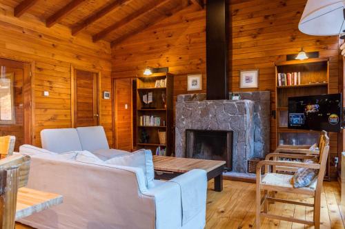 Cabaña de madera con sala de estar con chimenea en BOG Las Lomitas en Villa La Angostura
