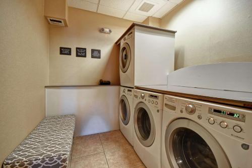 a laundry room with two washing machines and a bench at Hampton Inn & Suites Folsom in Folsom