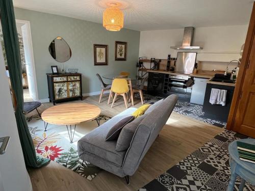 un salon avec un canapé et une table dans l'établissement La Maison du bonheur GÎTE LE COQUET, à Largentière