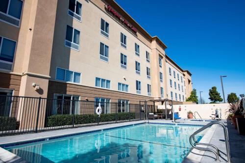 un hotel con piscina frente a un edificio en Hampton Inn & Suites Pittsburg en Pittsburg