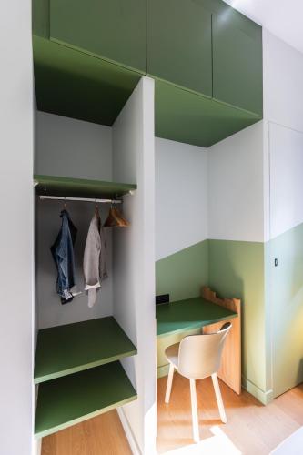 a room with green shelves and a white chair at Hôtel - Lodges de Lemptégy in Saint-Ours