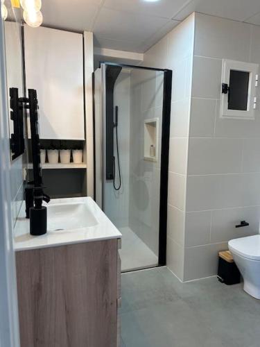 een badkamer met een douche, een wastafel en een toilet bij Apartamento a 20 m de playa Almería in Almería