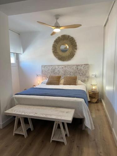 een slaapkamer met een bed, een plafondventilator en een spiegel bij Apartamento a 20 m de playa Almería in Almería