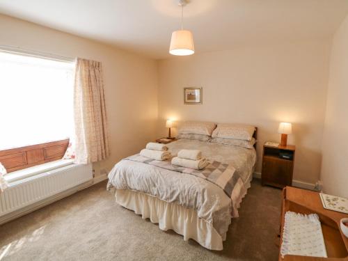 a bedroom with a bed with pillows and a window at Nook Farm Holiday Cottage in Sheffield