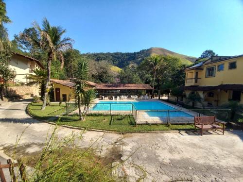 una piscina frente a una casa en Pousada Green Garden, en Engenheiro Paulo de Frontin