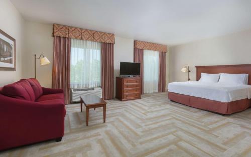 a hotel room with a bed and a couch and a tv at Hampton Inn & Suites Lodi in Lodi