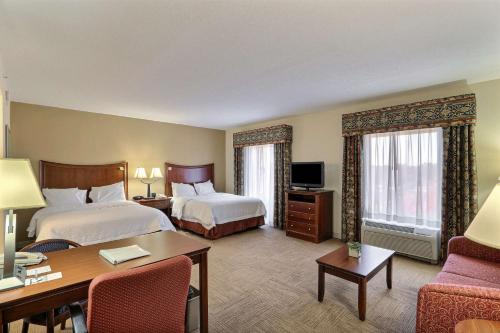 ein Hotelzimmer mit 2 Betten und einem Schreibtisch in der Unterkunft Hampton Inn & Suites Savannah - I-95 South - Gateway in Savannah