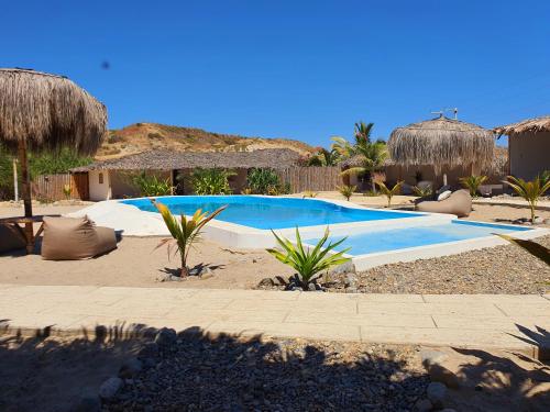a swimming pool in the middle of a resort at Oasis de Vichayito in Vichayito