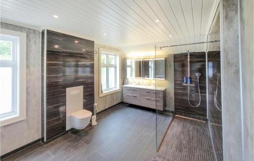 a bathroom with a shower and a toilet and a sink at Stunning Home In ystese With Wifi And 4 Bedrooms in Øystese