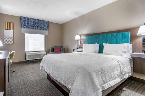 a hotel room with a large bed and a window at Hampton Inn & Suites Louisville East in Louisville