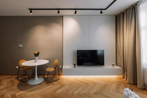 a living room with a tv and a table with chairs at Cherry Apartment in Bratislava