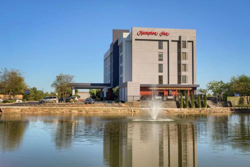 a building with a fountain in the middle of a pond at Hampton Inn Louisville Northeast in Louisville