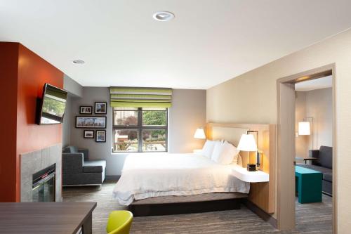 シアトルにあるハンプトン イン & スイーツ シアトル - ダウンタウンのベッドと椅子付きのホテルルーム