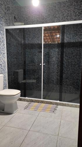 a bathroom with a glass shower with a toilet at Recanto do Sossego Saquarema in Saquarema