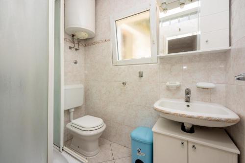a bathroom with a sink and a toilet and a window at Uremovic in Crikvenica