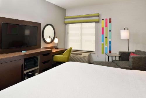 a hotel room with a bed and a television at Hampton Inn San Francisco - Daly City in Daly City